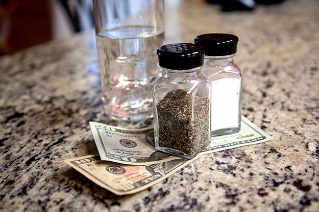 Tip left on counter with salt and pepper shakers holding the money in place.